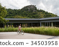 a short hair young woman is riding the bicycle 34503958