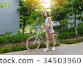 a short hair young woman with her bicycle 34503960