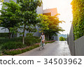 woman riding the bicycle with sunlight 34503962
