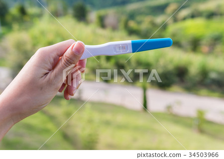 a woman hand holding pregnancy test a woman hand holding pregnancy test 34503966