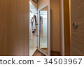 wooden wardrobe with some clothes 34503967