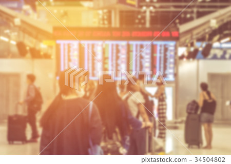 blurred Traveler at airport with flight schedule 34504802