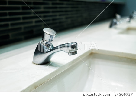 Luxury faucet on a white sink in the bathroom Luxury faucet on a white sink in the bathroom 34506737