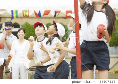 Elementary school students putting on ball at athletic meet 34507331