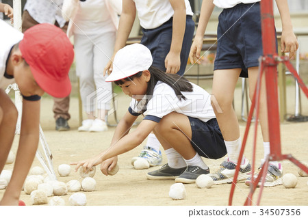 Elementary school students putting on ball at athletic meet 34507356