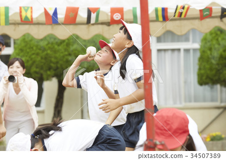 Elementary school students putting on ball at athletic meet 34507389