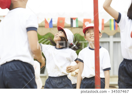Elementary school students putting on ball at athletic meet 34507467