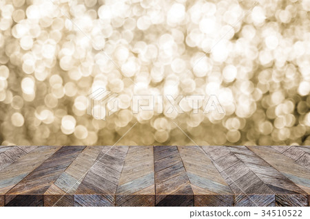 wood table top with blur sparkling gold bokeh 34510522