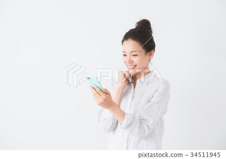 A woman who operates a smartphone (white background) A woman who operates a smartphone (white background) 34511945