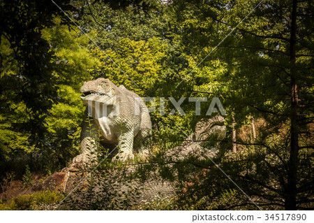 Dinosaur sculpture in a park 34517890