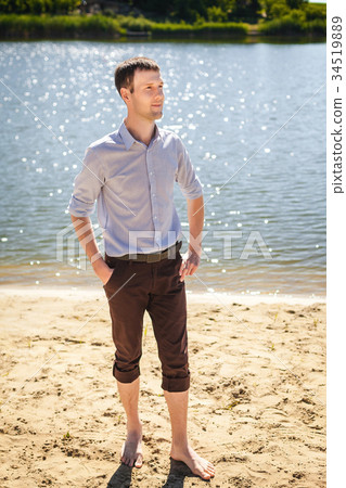 young man walking on cost river young man walking on cost river 34519889