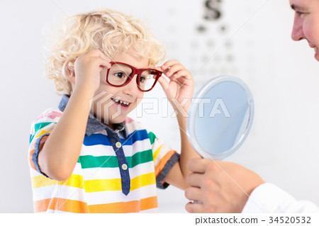 Child at eye sight test. Kid at optitian. Eyewear 34520532