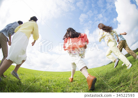 Rear of college students running in the grassland 34522593