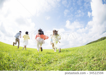 Rear of college students running in the grassland 34522594