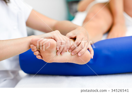 Medical massage at the foot in a physiotherapy center. Medical massage at the foot in a physiotherapy center. 34526541