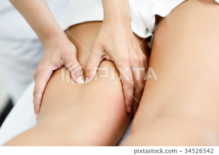 Medical massage at the leg in a physiotherapy center. 34526542