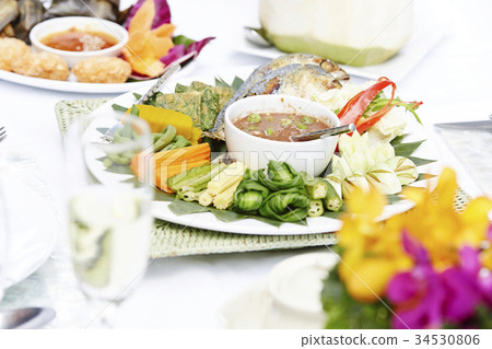 An image of Thai food called Nam-Prik-Pla-Too, with some other Thai dishes and a glass. 34530806