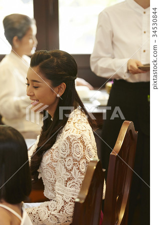 A happy woman is sitting in the restaurant. A happy woman is sitting in the restaurant. 34530844