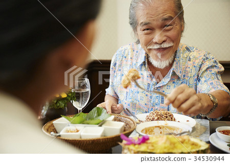 A senior man is enjoying Thai foods with his wife in a restaurant A senior man is enjoying Thai foods with his wife in a restaurant 34530944