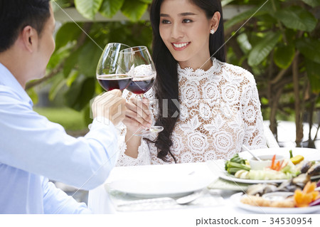 young couple has lunch together with red wine in restaurant young couple has lunch together with red wine in restaurant 34530954