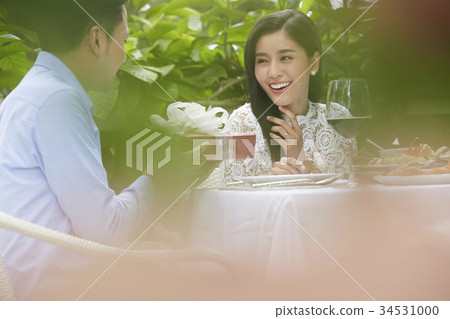 young man is giving a gift box to his girlfriend in a restaurant young man is giving a gift box to his girlfriend in a restaurant 34531000