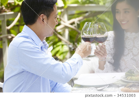 a romantic couple is clinking glassses of wine in a restaurant a romantic couple is clinking glassses of wine in a restaurant 34531003