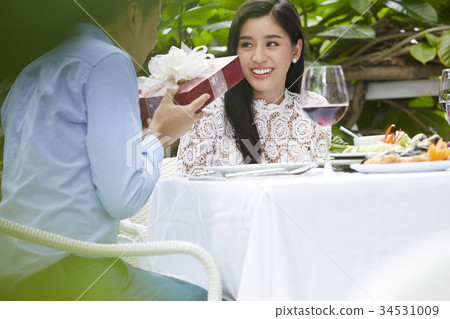 romantic boyfriend is giving a present for his girfiend in a restaurant romantic boyfriend is giving a present for his girfiend in a restaurant 34531009