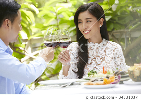 a young couple has a happy lunch with wine in a restaurant a young couple has a happy lunch with wine in a restaurant 34531037