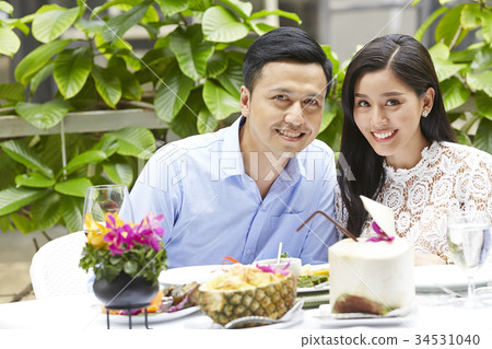 a happy couple is sitting and smiling when having lunch in a restaurant 34531040