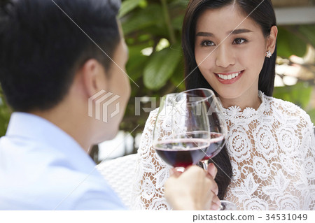 young woman is smiling with her boyfriend and drinking wine together 34531049