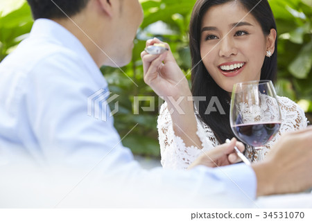 A young man is being feeded by his girlfriend at a lunch date. A young man is being feeded by his girlfriend at a lunch date. 34531070