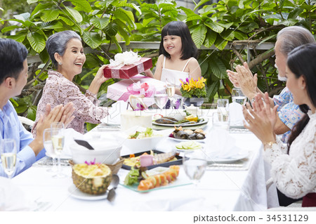 The grandmother is giving her niece a gift in party 34531129