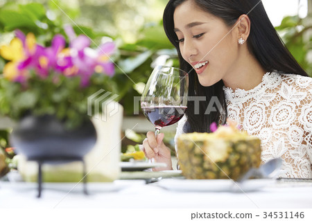 A beautiful girl is tasting the red wine 34531146