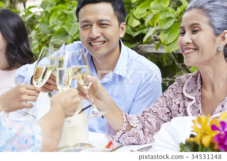 The man and his mother are holding glasses of wine to cheer up 34531148
