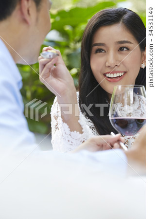 The woman is smilling and giving food for her husband 34531149