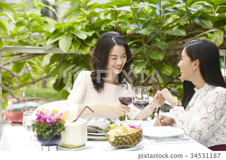 a young woman is enjoying wine with her friend in a luxurious restaurant 34531187