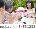 an adorable girl is giving gifts to her grandmother in her anniversary 34531232