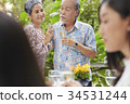 older man and woman are looking each other, cheering and smiling at a party 34531244