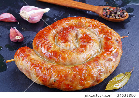 round fried spiral sausages on slate 34531896