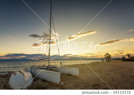 Sailboat on the beach at sunset 34533570