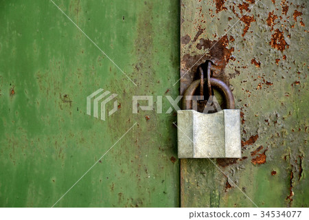 Old padlock on an old rusty iron door 34534077
