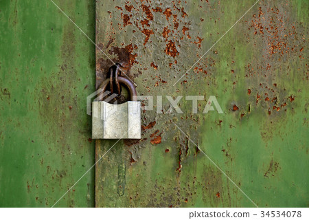 Old padlock on an old rusty iron door 34534078