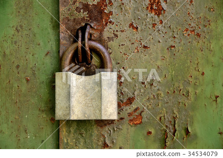 Old padlock on an old rusty iron door 34534079