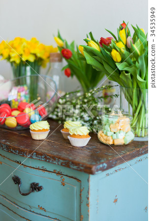 Bright macaroons and cupcakes on a wooden table 34535949