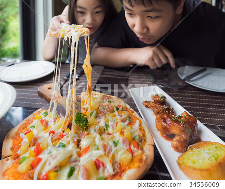 Brethren eat a pizza togather in restaurant 34536009