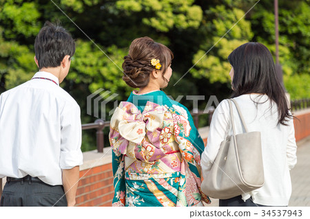 A woman wearing a kimono and a back of her family A woman wearing a kimono and a back of her family 34537943