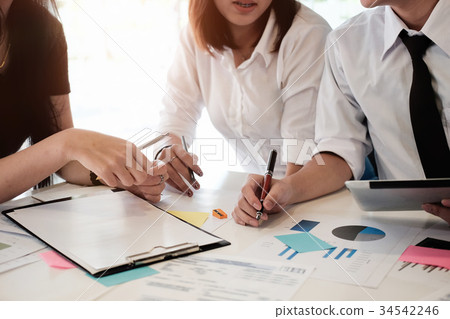 Business team analyzing financial data in report. 34542246