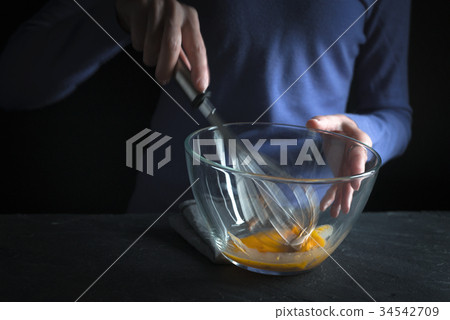Beat yolks in a glass bowl with a whisk  34542709