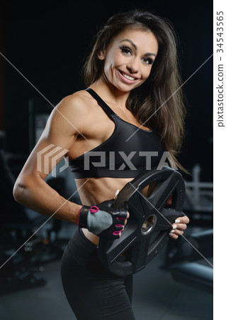 Sexy athletic young girl working out in gym Sexy athletic young girl working out in gym 34543565