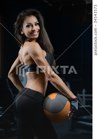 Sexy athletic young girl training arms in gym Sexy athletic young girl training arms in gym 34543573